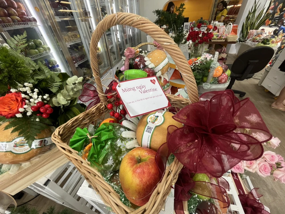 Một cửa hàng trái cây nhập khẩu trang trí hoa tươi và lời chúc 14-2 cho khách hàng có nhu cầu tặng trong ngày lễ tình nhân