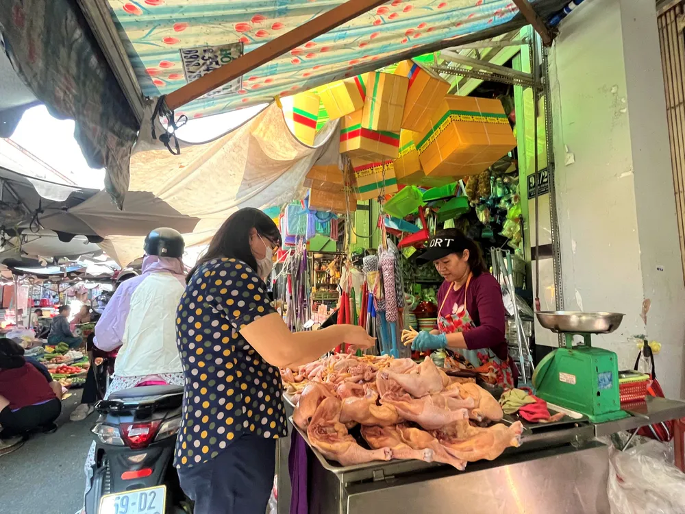 Người dân mua thịt gà tại chợ truyền thống. ẢNH: TÚ UYÊN