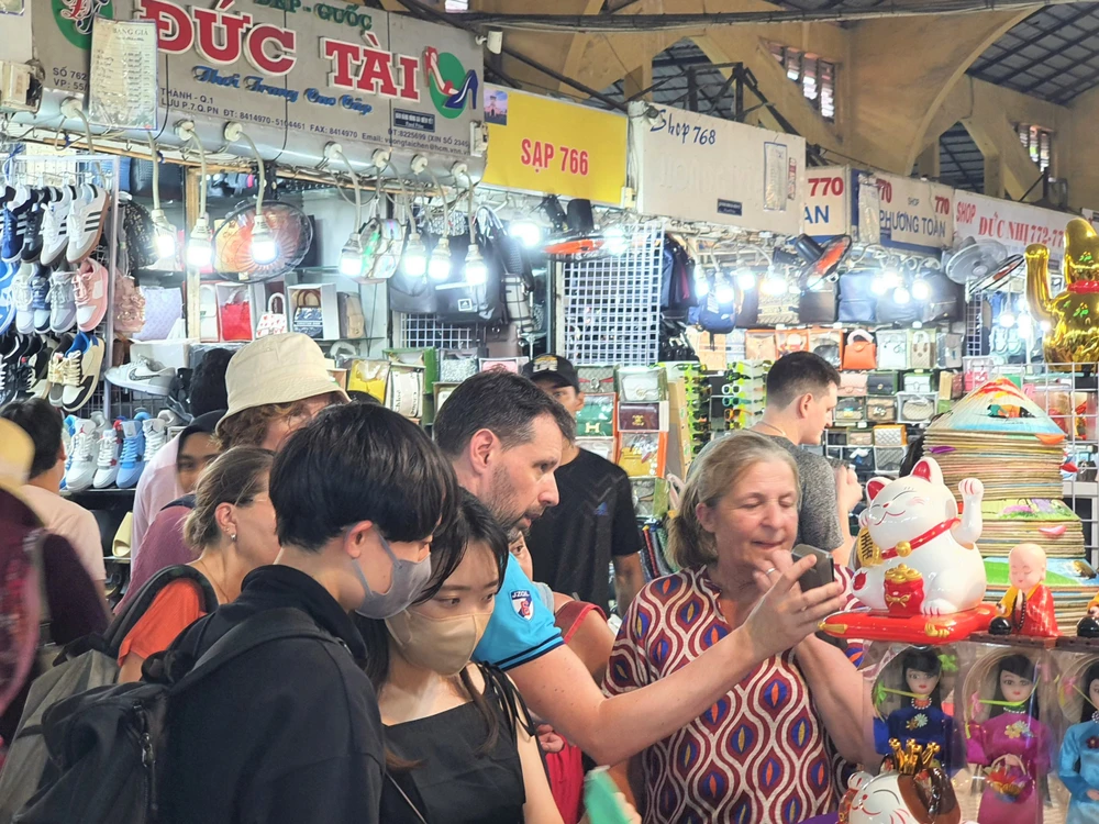 Du khách đang trao đổi giá tại sạp bán hàng lưu niệm