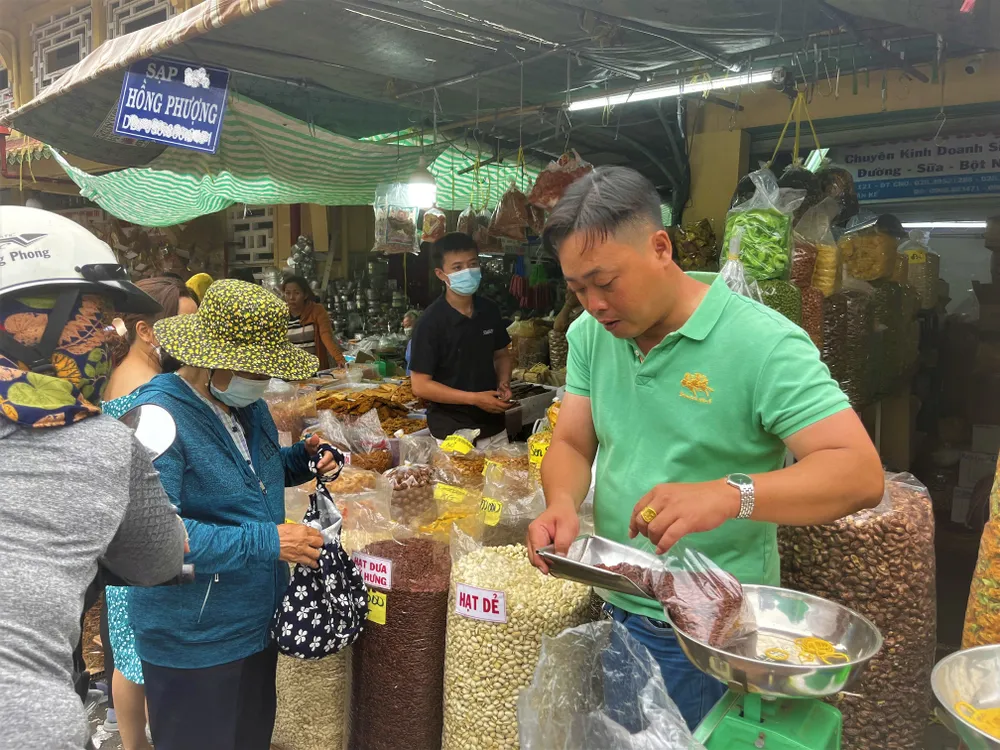 Người dân mua sắm các mặt hàng bánh kẹo, hạt dưa đón Tết 2023. ẢNH: TÚ UYÊN tet-hat-dua.jpg