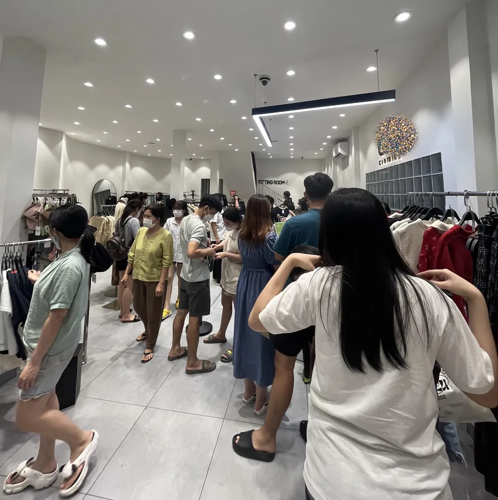 Một cửa hàng trên đường Trần Huy Liệu nhiều khách đang chọn quần áo và chờ tính tiền.