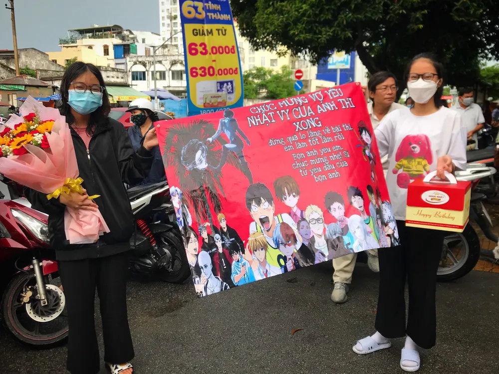 Dù trời mưa nặng hạt nhưng hai em Mai Tuyết Hạnh và Nguyễn Thu Phương vẫn hào hứng đứng chờ chị gái trước điểm thi. Ảnh: TÚ NGÂN.