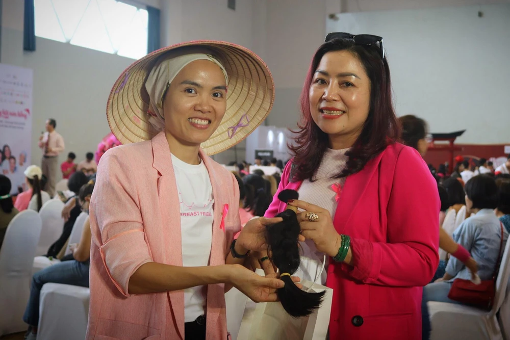 Chị Thùy Trang (42 tuổi, quận Gò Vấp) thay con gái chỉ mới 13 tuổi mang tóc đến tặng ngày hội. Ảnh: TÚ NGÂN