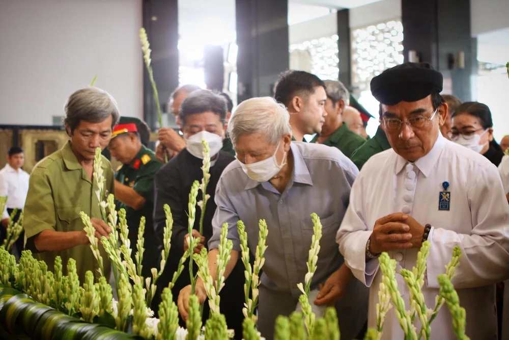 Đại diện gia đình có người thân mất vì COVID-19 dâng hoa tại khu vực tưởng niệm. Ảnh: TÚ NGÂN