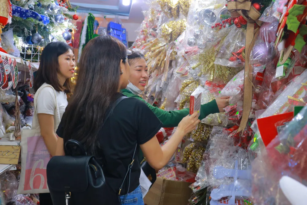 Chị Minh Thư cùng bạn bè ghé các cửa hàng để lựa chọn phụ kiện trang trí và làm thiệp mừng Giáng sinh. Ảnh: VÕ THƠ Chị Minh Thư cùng bạn bè ghé các cửa hàng để lựa chọn phụ kiện trang trí và làm thiệp mừng Giáng sinh