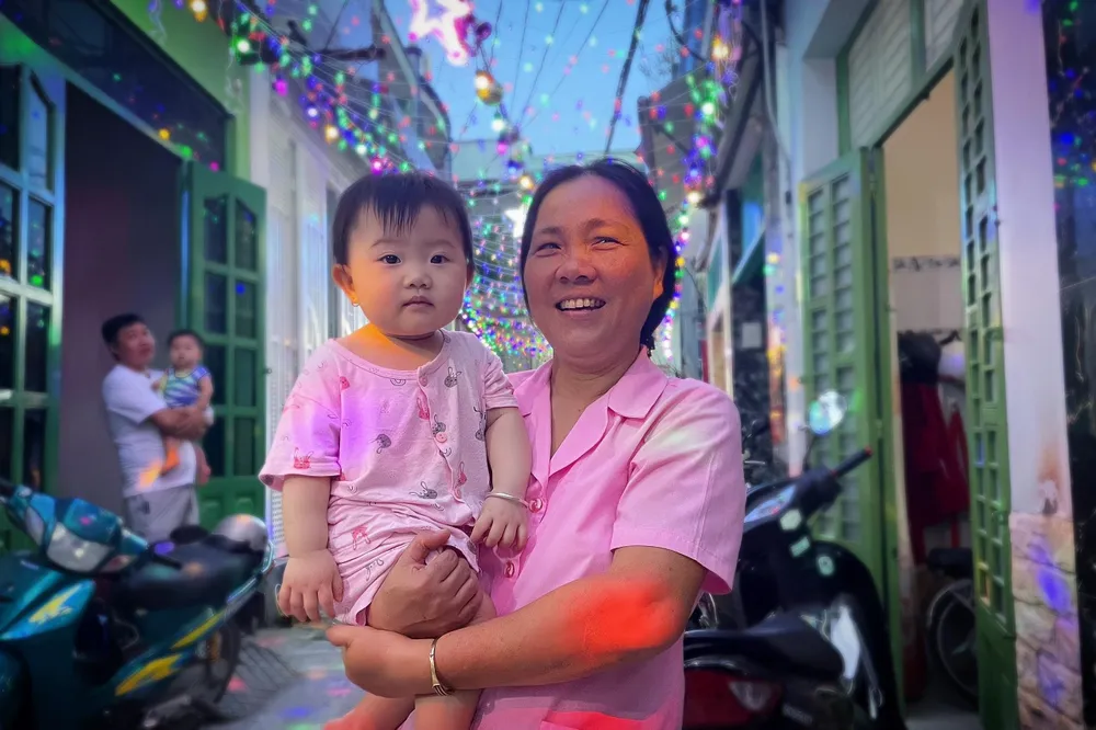 Cô Trần Thị Dung hào hứng bế cháu dạo quanh con hẻm nhỏ.