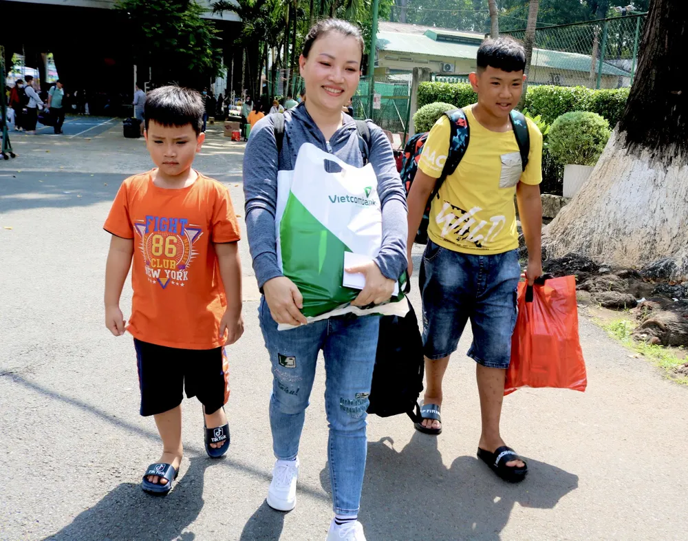 Hai cậu con trai của chị Lê Thị Loan theo mẹ về quê đón Tết. Ảnh: TÚ NGÂN