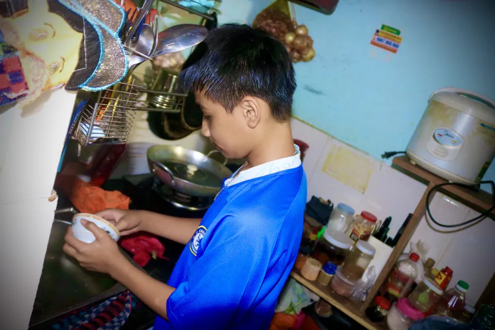 Em Hoàng Minh Hiếu (14 tuổi) phụ giúp cha mẹ những việc lặt vặt để sửa soạn cúng giao thừa. Ảnh: TÚ NGÂN Em Hoàng Minh Hiếu (14 tuổi) phụ giúp cha mẹ những việc lặt vặt để sửa soạn cúng giao thừa. Ảnh: TÚ NGÂN