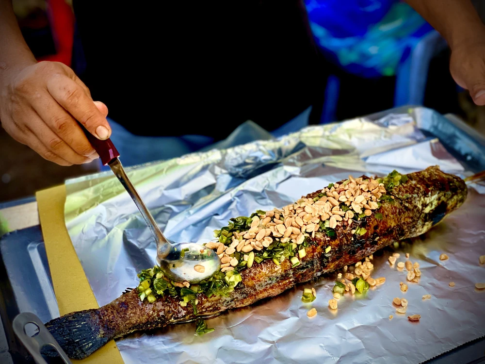 Cá nướng thành phẩm được cho thêm gia vị, đậu phộng, mỡ hành và bọc bằng giấy bạc đến tay khách hàng. Cá giữ được độ ấm và vị ngon một cách tốt nhất. Ảnh: TÚ NGÂN