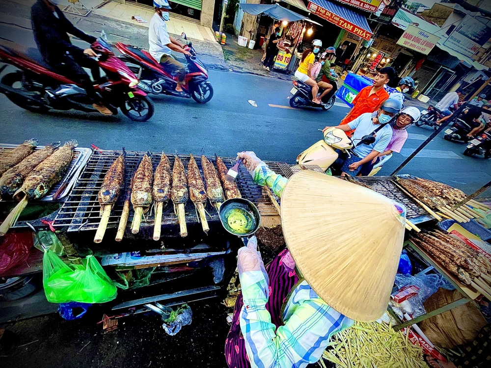 Mùi cá lóc nướng đã thơm lừng, ngào ngạt cả con phố. Ảnh: TÚ NGÂN