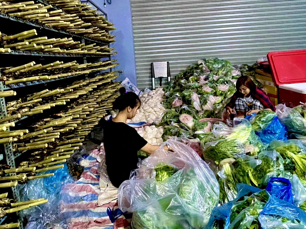 Nhân viên cửa hàng đang tất bật chuẩn bị rau, bún, bánh tráng, nước chấm cho bán cùng cá lóc nướng.