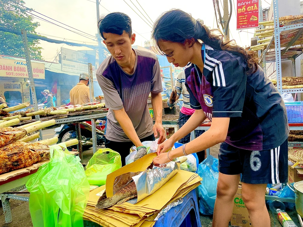 Nhân viên liên tục gói cá giao cho khách.