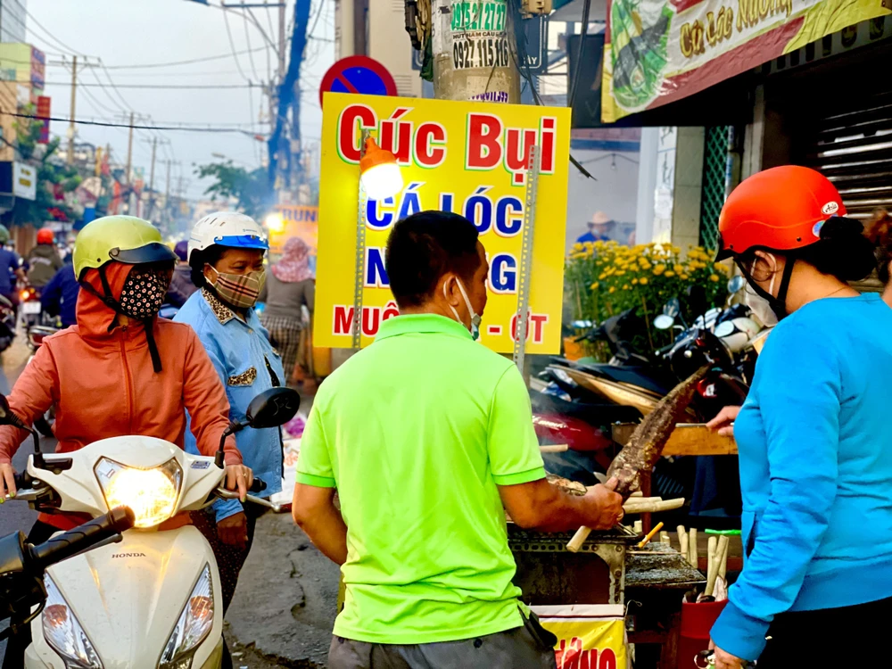 Khách hàng đến từ tờ mờ sáng để lựa chọn cá lóc nướng.