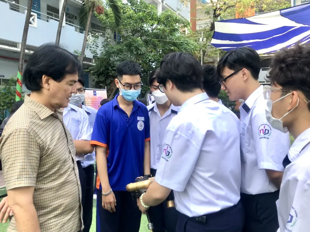 Ông Huỳnh Thanh Phú, hiệu trưởng trường trao đổi với học sinh về các sản phẩm khoa học.Ảnh: KHÁNH TRÚC