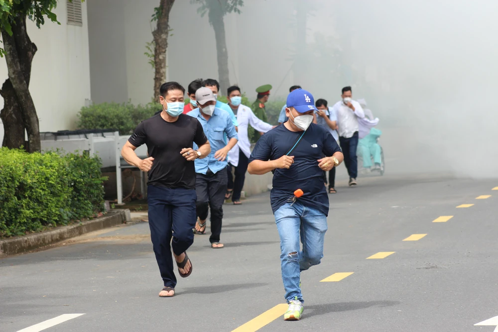 Nhiều người rời khỏi đám cháy khi có chuông báo cháy. Ảnh: TS