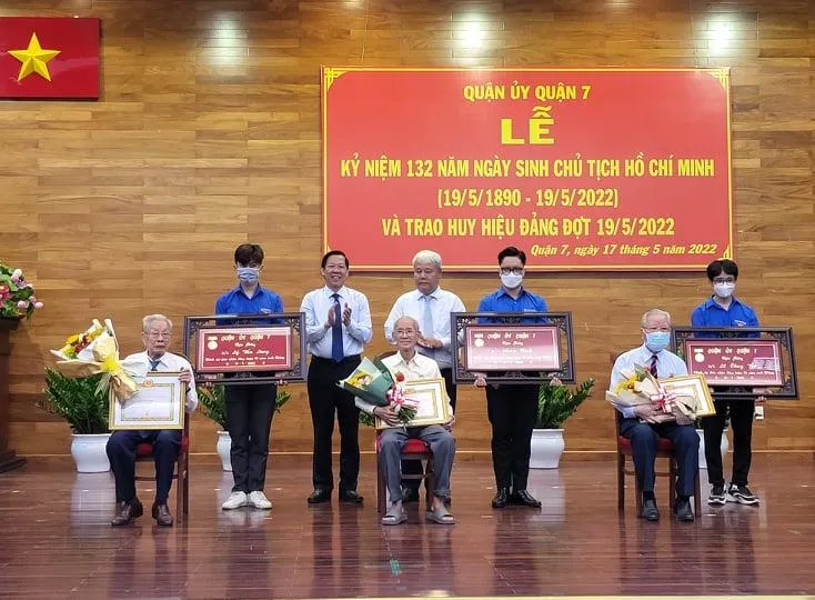 Ông Phan Văn Mãi, Chủ tịch UBND TP.HCM cùng lãnh đạo quận 7 trao huy hiệu 75 năm tuổi Đảng cho người có công với cách mạng. Ảnh: TS