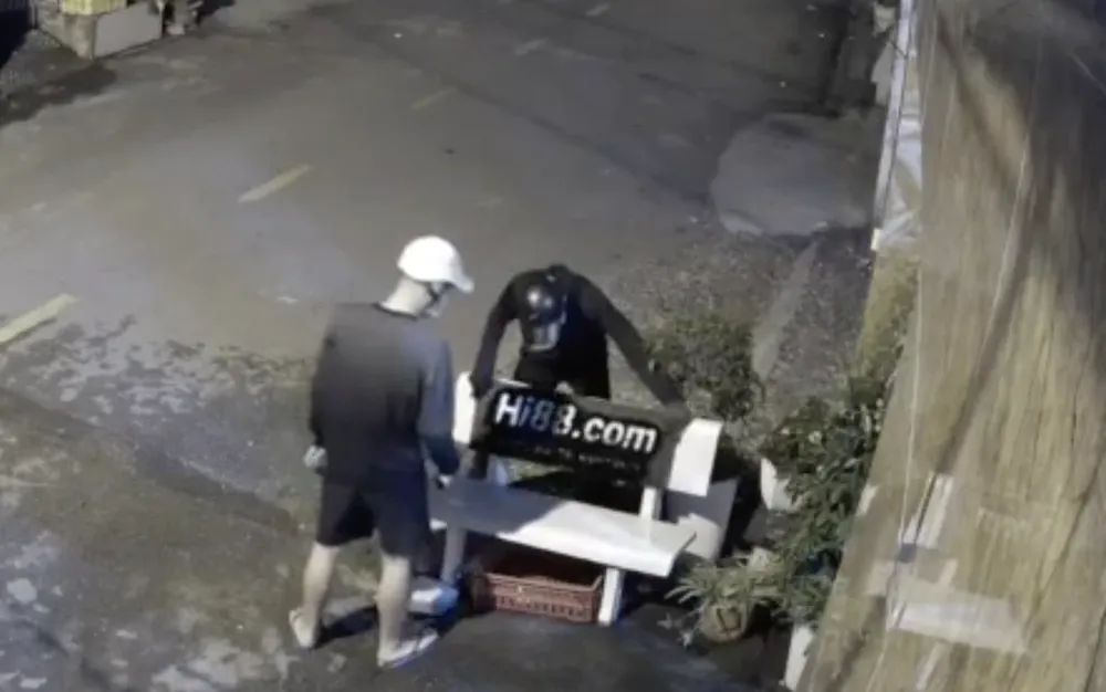 Camera ghi lại cảnh Quí và Được dùng khuôn để xịt sơn lên ghế đá với dòng chữ Hi88.com. Ảnh: TS