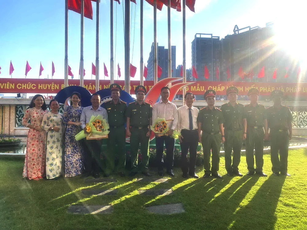Lãnh đạo Huyện ủy - UBND - Công an huyện Bình Chánh và Phòng PC02 Công an TP.HCM cùng PV Tự Sang và Võ Tùng của báo Pháp luật TP.HCM. Ảnh: BT khen-mua-ban-than.jpg