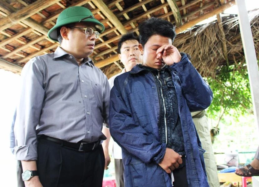 Ông Hoàng Văn Trà, Chủ tịch UBND tỉnh Phú Yên, động viên cháu Phan Nguyên Thi (phường Xuân Đài, thị xã Sông Cầu) có cha bị mất tích do lũ. Ảnh: TẤN LỘC