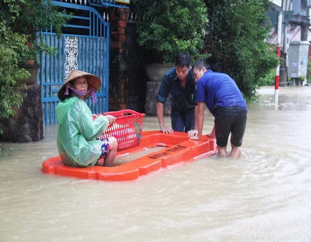 Lực lượng thanh niên xung kích xã Phước Lộc, huyện Tuy Phước (Bình Định) đưa người già đi tránh lũ.