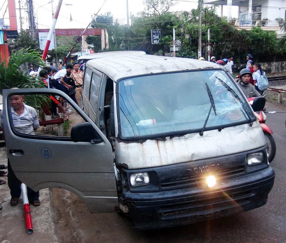 Chiếc xe 16 chỗ lao vào gác chắn đường sắt khi tàu sắp qua. Ảnh: CTV