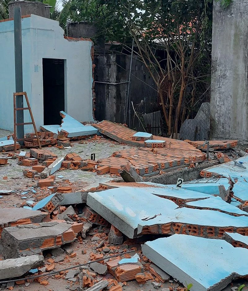 Bức tường bị sập, đè chết hai người. Ảnh: CA