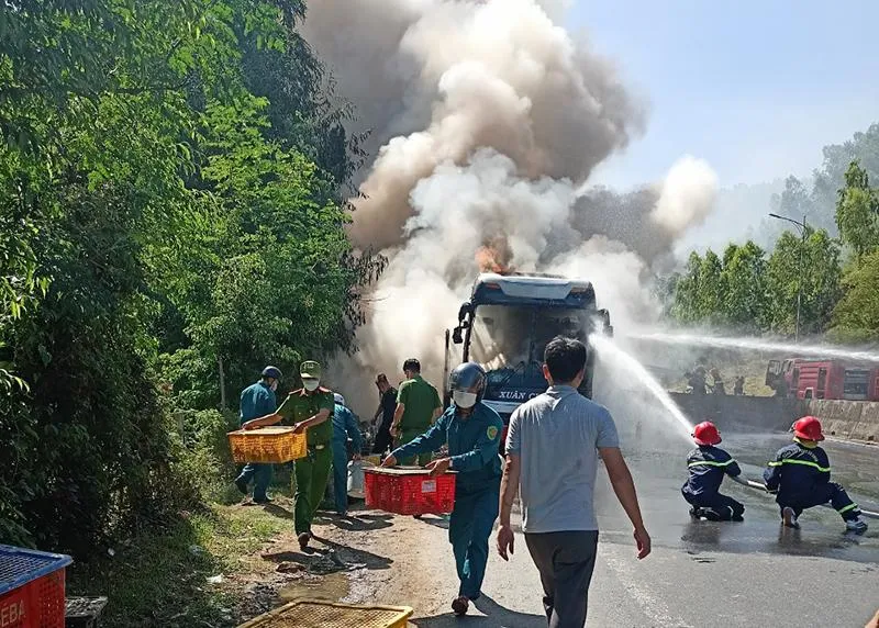 Lực lượng chức năng, người dân giúp đưa hàng hóa ra khỏi chiếc xe bị cháy. Ảnh: V.PHONG Lực lượng chức năng, người dân giúp đưa hàng hóa ra khỏi chiếc xe bị cháy. Ảnh: V.PHONG