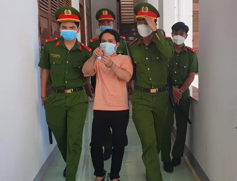 Lực lượng công an dẫn giải bị cáo Đoàn Minh Hải. Ảnh: TẤN LỘC