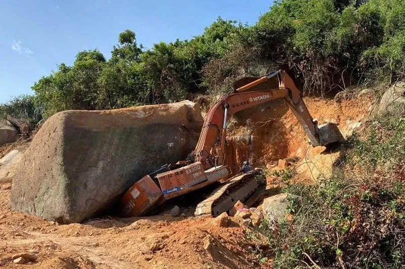 Tảng đá lớn đè chiếc xe múc. Ảnh: TQ Tảng đá lớn đè chiếc xe múc. Ảnh: TQ