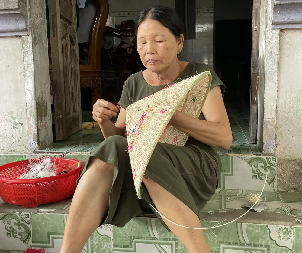 Bà Huỳnh Thị Hạnh cho biết nón ngựa tạo nên từ những bàn tay khéo léo, tài hoa của người thợ thủ công gắn bó với nghề khi còn rất trẻ. Ảnh: THU DỊU 3.jpg