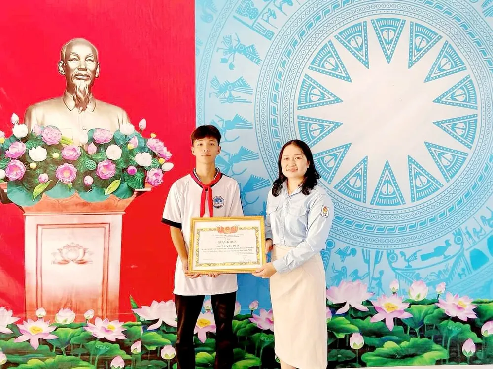 Bà Huỳnh Thị Thanh Nguyệt trao bằng khen cho em Lê Văn Phát về hành động dũng cảm cứu bạn đuối nước kịp thời. Ảnh:NT đuối nước.jpg