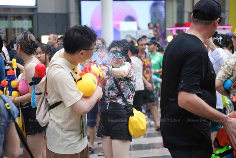 Khách du lịch tham gia lễ hội té nước Songkran gần trung tâm mua sắm CentralWorld ở thủ đô Bangkok (Thái Lan) ngày 13-4. Ảnh: THE BANGKOK POST