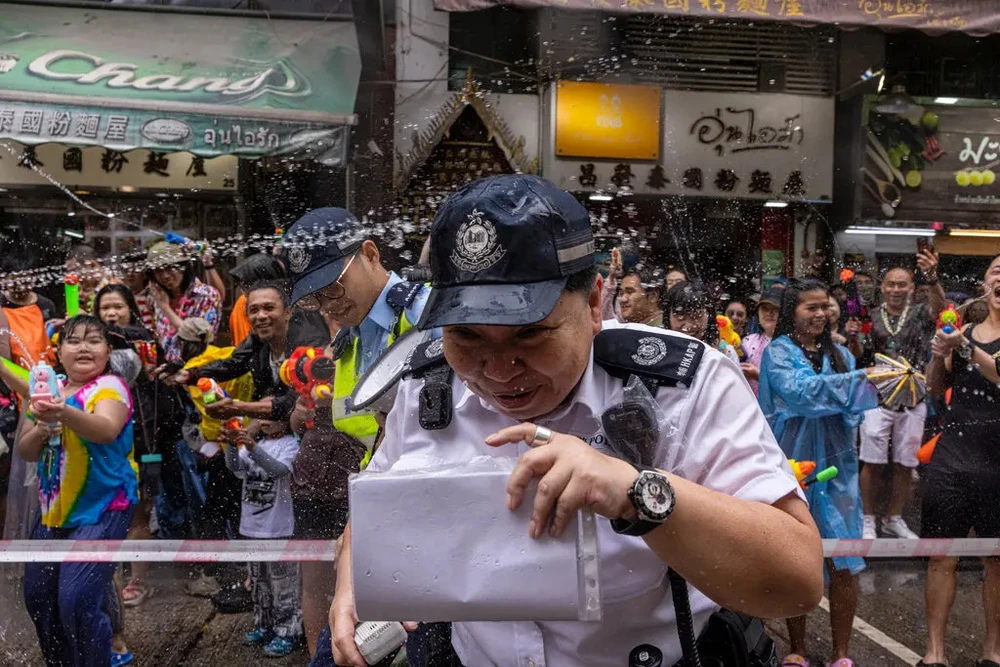 Người tham gia lễ hội Songkran ở Hong Kong tạt nước vào các sĩ quan cảnh sát hôm 9-4. Ảnh: AP