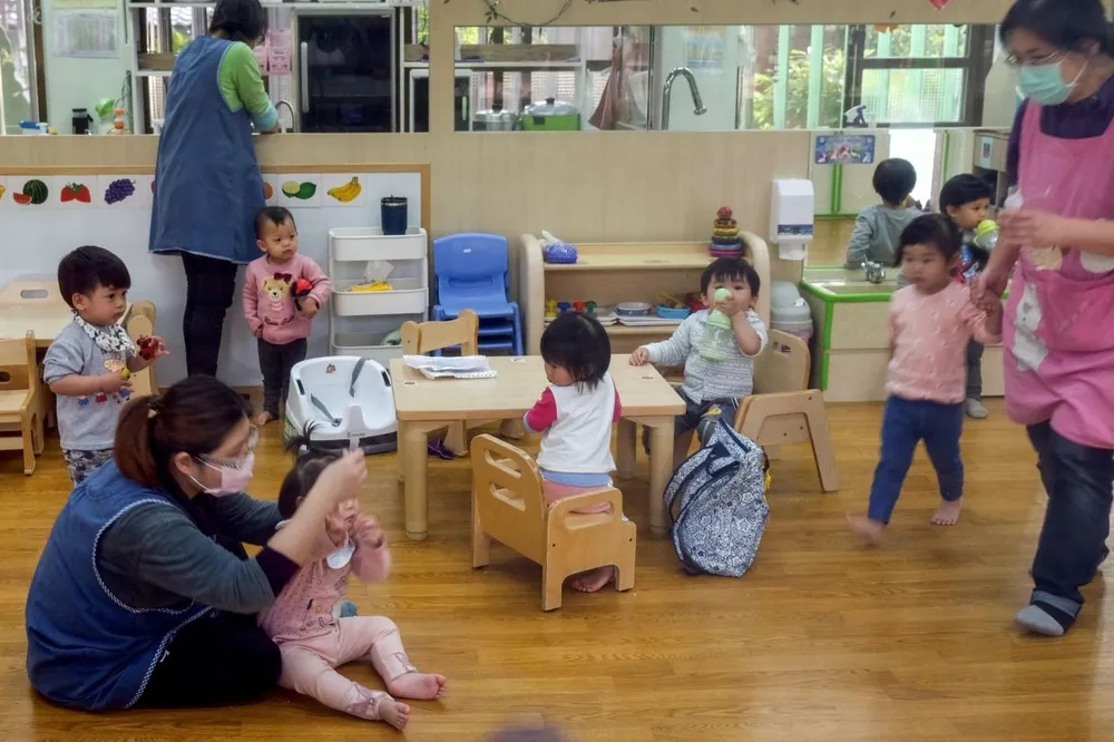 Giáo viên mầm non tại Đài Loan đang chăm sóc trẻ em. Ảnh: AFP