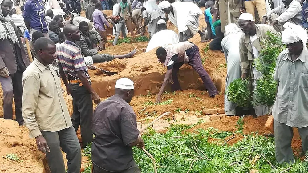 Người dân đào hố chôn tập thể các nạn nhân của vụ tấn công khiến hơn 60 người thiệt mạng, tại vùng Darfur (Sudan) vào tháng 7-2020. Ảnh: AP