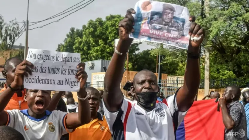 Người biểu tình ở thủ đô Niamey (Niger) giơ cao tấm biển có nội dung “Chúng tôi yêu cầu tất cả các lực lượng phương Tây rút khỏi Niger”, hôm 21-7. Ảnh: AFP