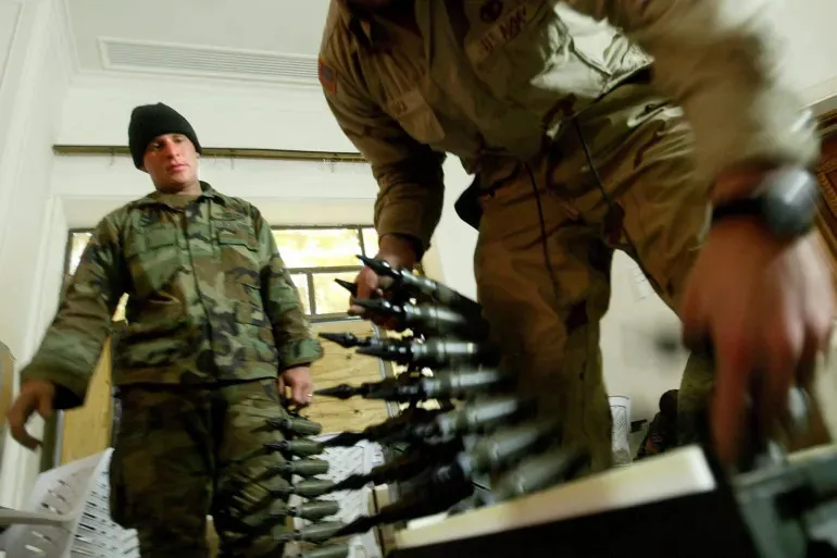 Lính Mỹ đóng gói đạn uranium nghèo 25 mm vào hộp đạn tại một căn cứ ở TP Tikrit (Iraq) năm 2004. Ảnh: EPA