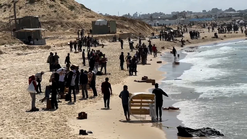 Người dân tập trung trên bãi biển ở ở Beit Lahia (Dải Gaza) ngày 26-3 để chờ hàng viện trợ thả từ máy bay. Ảnh: CNN gaza 1.jpg
