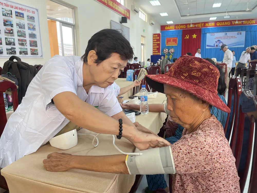 Bác sĩ kiểm tra huyết áp cho người dân. Ảnh: THẢO VY Bác sĩ kiểm tra huyết áp cho người dân. Ảnh: THẢO VY