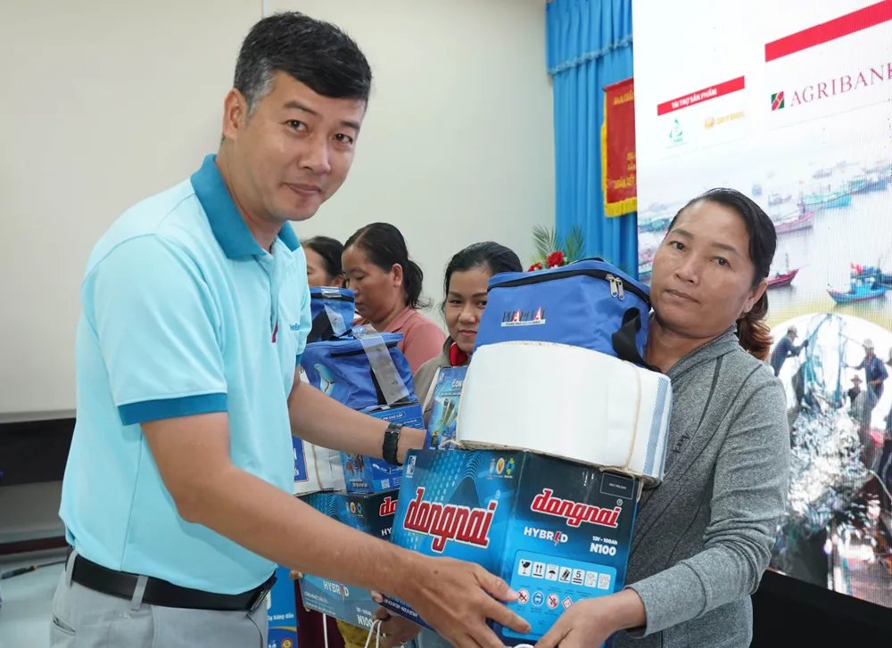 Đại diện nhà tài trợ trao quà cho ngư dân. Ảnh: THUẬN VĂN cung-ngu-dan-thap-sang-den-tren-bien-6.jpg