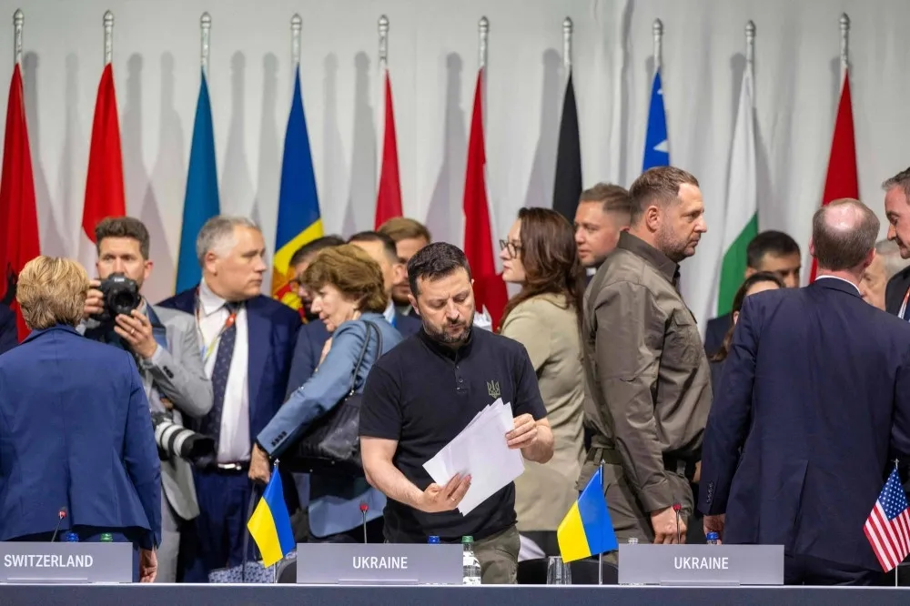 Tổng thống Ukraine Volodymyr Zelensky (giữa) xem các giấy tờ khi ông tham dự phiên họp toàn thể trong hội nghị thượng đỉnh hòa bình Ukraine tổ chức tại Thụy Sĩ vào hôm 16-6. Ảnh: AFP Hơn 80 quốc gia, tổ chức ký thông cáo chung của thượng đỉnh hòa bình Ukraine