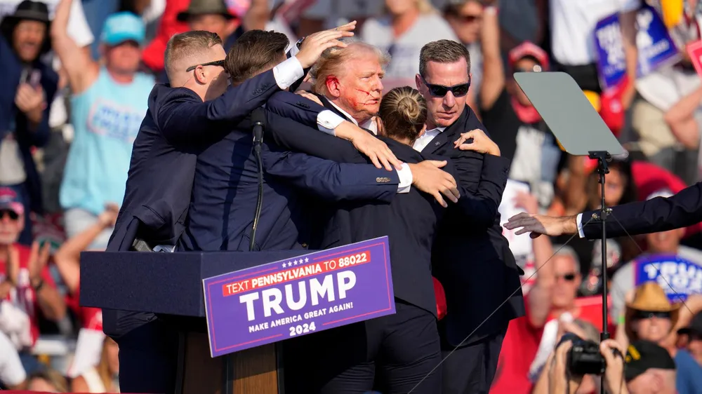 Cựu Tổng thống Donald Trump được dìu xuống sân khấu sau khi bị ám sát hụt tại một sự kiện vận động tranh cử ở bang Pennsylvania ngày 13-7. Ảnh: AP Nga, trung Quốc bình luận vụ ông Trump bị ám sát hụt