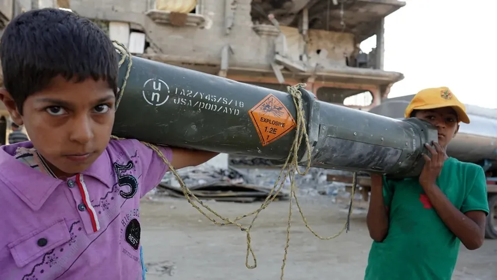 Trẻ em Palestine mang theo một thùng đạn rỗng của Mỹ ở TP Khan Younis (phía nam Dải Gaza) ngày 16-5. Ảnh: AFP cung-cap-vu-khi-cho-israel (2).jpg