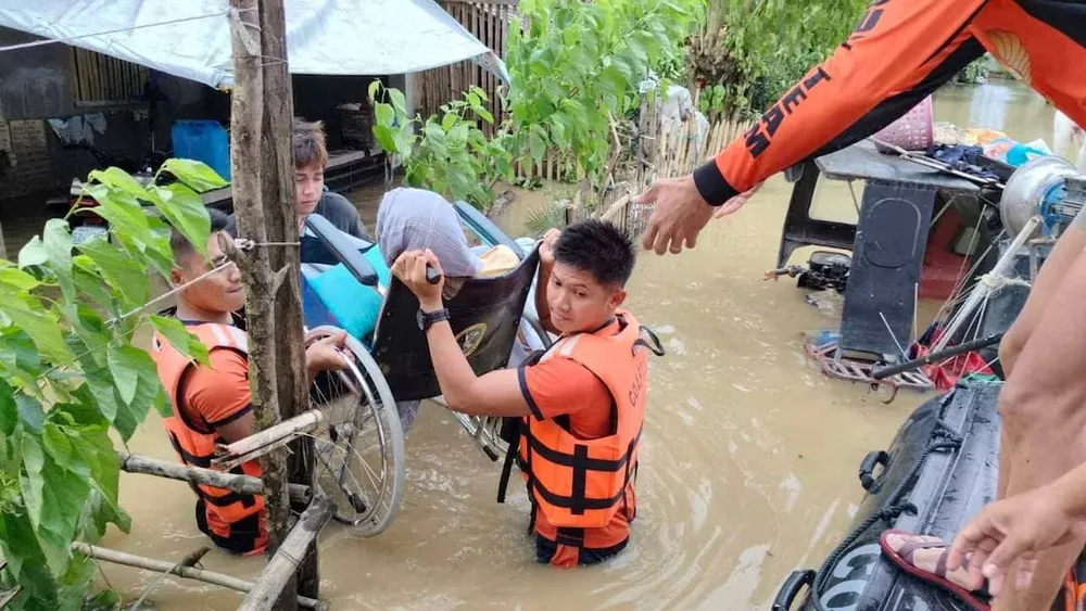 Lực lượng bảo vệ bờ biển Philippines sơ tán người dân sau khi nước lũ dâng cao do cơn bão Trà Mi gây ra ở tỉnh Camarines Sur (Philippines) ngày 24-10. Ảnh: REUTERS Cơn bão Trà Mi (1).jpg