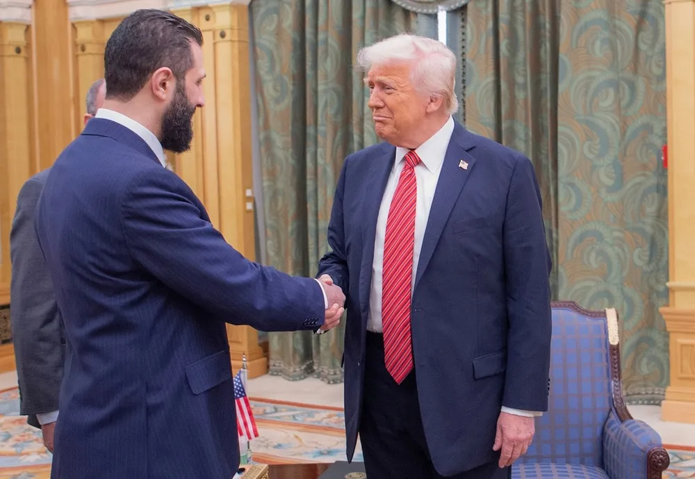 Tổng thống Mỹ Donald Trump (phải) bắt tay Tổng thống lâm thời Syria - ông Ahmed al-Sharaa tại Saudi Arabia ngày 14-5. Ảnh: HOÀNG GIA SAUDI ARABIA Các tiếp cận độc đáo, hiệu quả của tổng thống lâm thời Syria với ông Trump