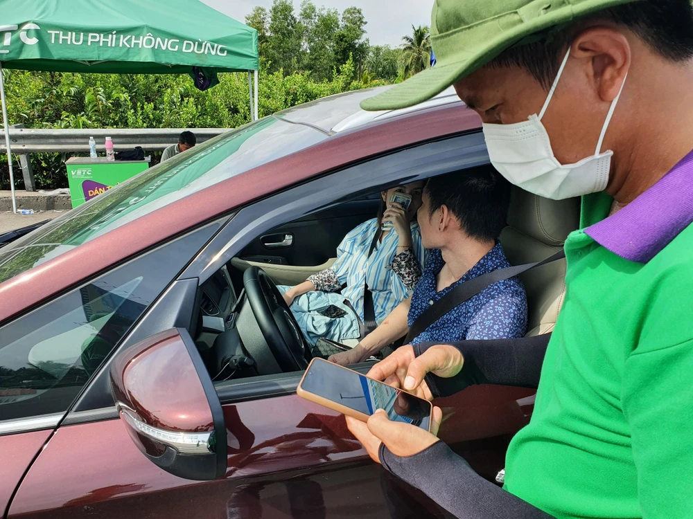 Nhân viên VEC đang hướng dẫn các xe dán thẻ ETC và cài đặt tài khoản