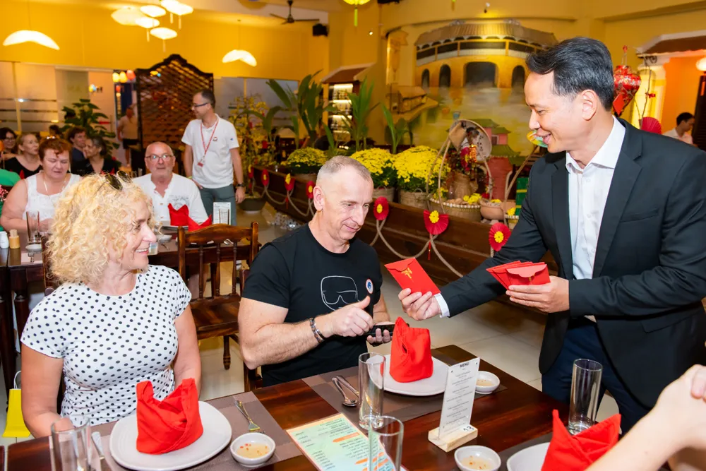 Khách du lịch quốc tế trải nghiệm văn hóa Tết truyền thống của người Việt Nam trong dịp Tết Nguyên đán 2024. Ảnh: THU TRINH