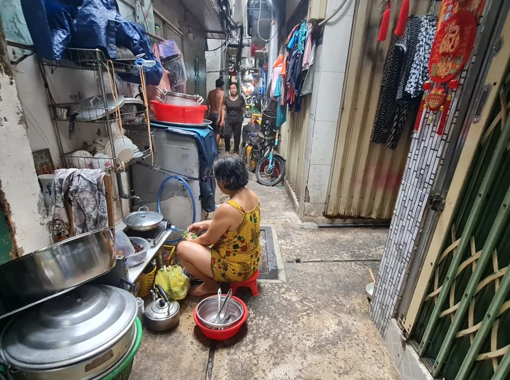 Gia đình ông Lâm phải ra ngoài hẻm để nấu nướng vì trong nhà quá chật hẹp. Ảnh: NGUYỄN CHÂU khu chợ gà.jpg