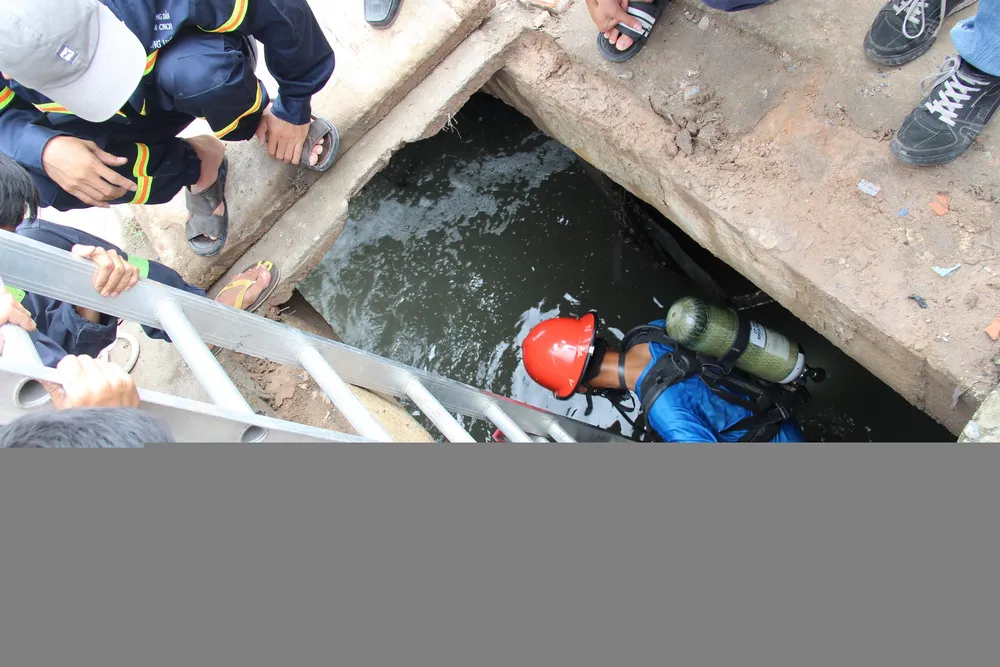 Người nhái xuống cống để tìm kiếm nạn nhân - Ảnh: Bá Sơn