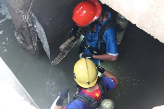 Người nhái lặn ngụp dưới cống nỗ lực tìm cháu bé - Ảnh: Bá Sơn